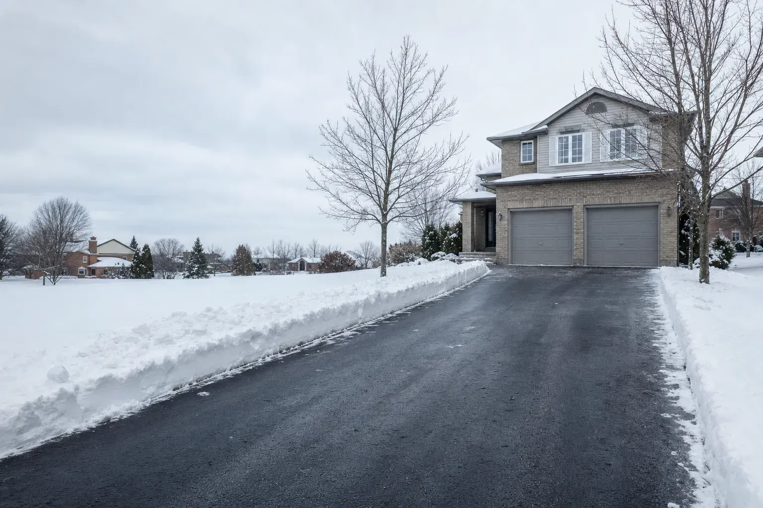 Residential snow removal in Oakville: a cleared driveway with snow banked on both sides